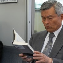 Father reading book on train