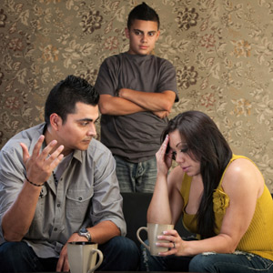 Frustrated Latino parents with sullen teenage son