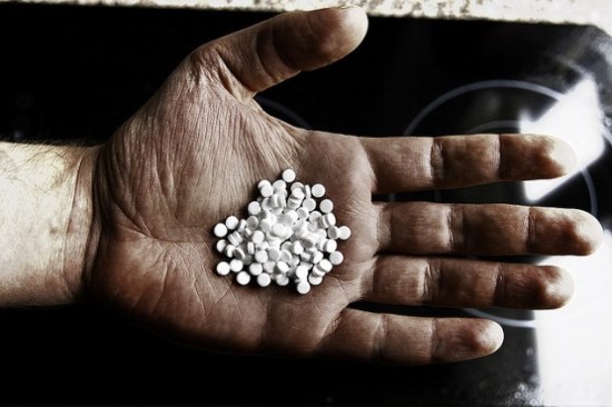 Older man's hand holding medication