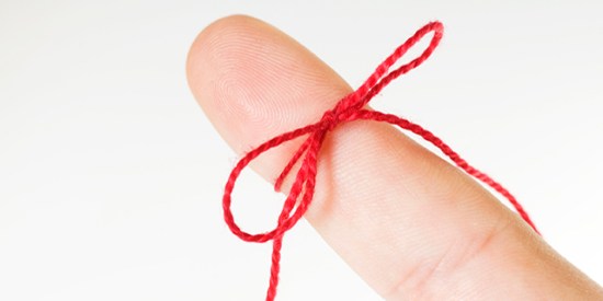 Red ribbon tied around finger