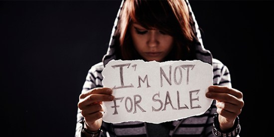 Teen girl holding "I'm not for sale" sign