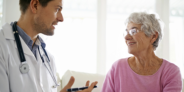 Smiling older woman chatting with doctor