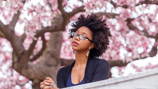 Professional black woman under cherry blossoms
